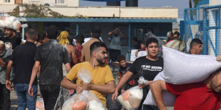لحظة قيام الآلاف من الفلسطينيين اقتحام مركز توزيع المساعدات الإسرائيلي