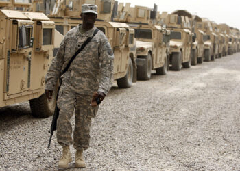 TO GO WITH AFP STORY BY ARTHUR MACMILLAN
A US soldier stands in front of a line of armoured vehicles at Camp Victory, a giant sprawling military base on the edge of Baghdad airport, on June 24, 2010 as American troops sort through the mass of hardware and supplies that must either be taken home, sent to Afghanistan, or destroyed, two months ahead of a deadline that will serve as a precursor for a complete US military pullout from Iraq. AFP PHOTO / AHMAD AL-RUBAYE (Photo by AHMAD AL-RUBAYE / AFP) (Photo by AHMAD AL-RUBAYE/AFP via Getty Images)