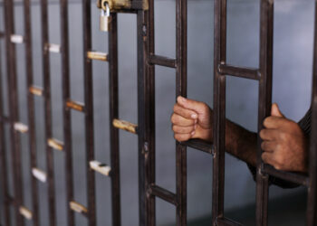 In this Friday, Aug. 24, 2012 photo, a Syrian prisoner holds the bars of a makeshift prison run by rebels in a former elementary school in Al-Bab on the outskirts of Aleppo, Syria. Many improvised detention centers have sprung up as rebels wrest cities from army control, but these facilities fall under no national or regional authority, causing concern among rights groups. (AP Photo/Muhammed Muheisen)