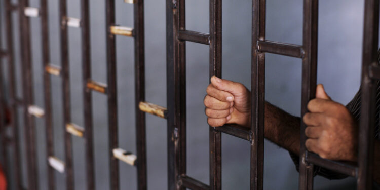 In this Friday, Aug. 24, 2012 photo, a Syrian prisoner holds the bars of a makeshift prison run by rebels in a former elementary school in Al-Bab on the outskirts of Aleppo, Syria. Many improvised detention centers have sprung up as rebels wrest cities from army control, but these facilities fall under no national or regional authority, causing concern among rights groups. (AP Photo/Muhammed Muheisen)