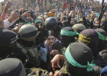 Israeli soldier Arbel Yehoud, 29, who has been held hostage by Hamas in Gaza since October 7, 2023, is escorted by Hamas and Islamic Jihad fighters as she is handed over to the Red Cross in Khan Younis, southern Gaza Strip, Thursday Jan. 30, 2025.(AP Photo/Jehad Alshrafi)