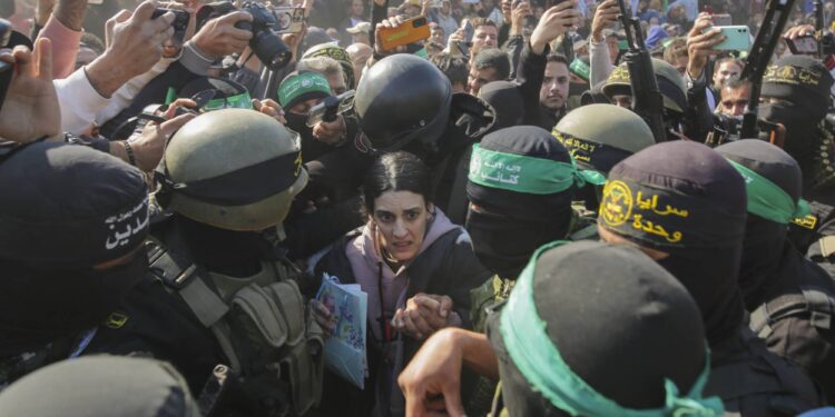 Israeli soldier Arbel Yehoud, 29, who has been held hostage by Hamas in Gaza since October 7, 2023, is escorted by Hamas and Islamic Jihad fighters as she is handed over to the Red Cross in Khan Younis, southern Gaza Strip, Thursday Jan. 30, 2025.(AP Photo/Jehad Alshrafi)