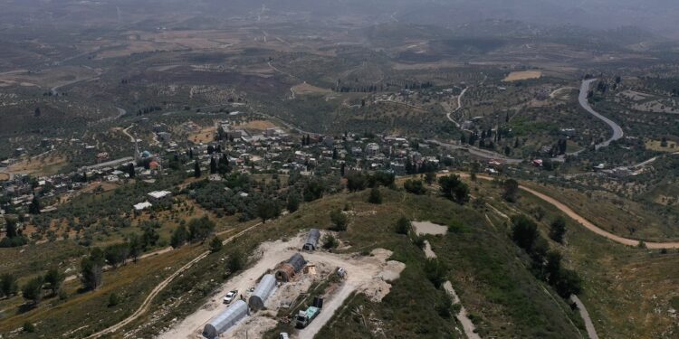 An aerial view shows the Israeli settler outpost of Homesh (C-bottom), near the Palestinian village of Burqah, in the occupied West Bank, on May 29, 2023. - Israeli settlers started reviving the flashpoint outpost settlement in the occupied West Bank on May 29, which had been evacuated nearly two decades prior, constructing a building at the site which has drawn international attention. The latest development comes weeks after the office of Prime Minister Benjamin Netanyahu pledged his government had no plans to reconstruct the site, after a parliamentary vote on the matter sparked ire abroad. (Photo by Menahem KAHANA / AFP)