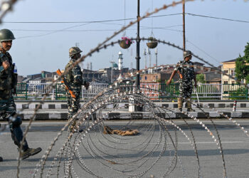 In this photo taken on August 5, 2019, Indian paramilitary troopers stand guard near a barbed fence wire as they block a road during a curfew in Srinagar. - India's home affairs minister on August 6 hailed "historic" legislation to bring Kashmir under its direct control, as New Delhi stepped up its clampdown on dissent in the restive Muslim-majority region. (Photo by TAUSEEF MUSTAFA / AFP)        (Photo credit should read TAUSEEF MUSTAFA/AFP/Getty Images)