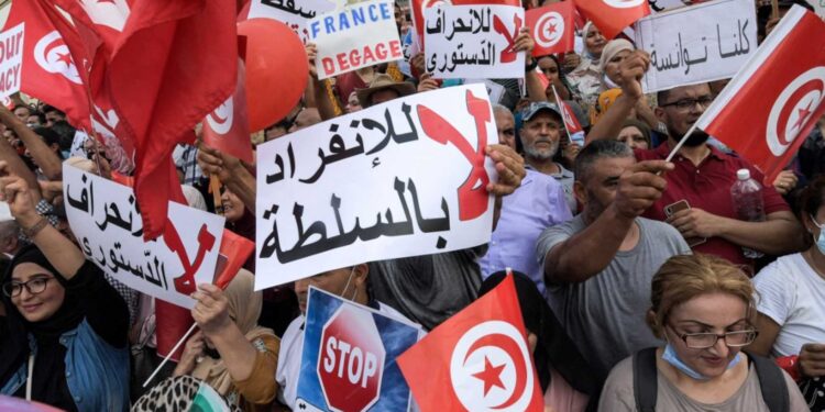 Demonstrators chant slogans during a protest in Tunisia's capital Tunis on September 26, 2021, against President Kais Saied's recent steps to tighten his grip on power. - Saied had on July 25 sacked prime minister Hichem Mechichi, suspended parliament and granted himself judicial powers. On September 22 he also announced "exceptional measures" that allow him to rule by decree. (Photo by FETHI BELAID / AFP)