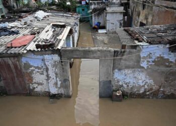 A general view shows houses inundated near banks of overflowing river Yamuna, after heavy monsoon rains in New Delhi on August 19, 2025. (Photo by Sajjad HUSSAIN / AFP)