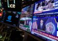 Screens display a news conference held by Federal Reserve chairman Kevin Warsh on the floor of the New York Stock Exchange in New York, Wednesday, Sept. 16, 2026. (AP Photo/Seth Wenig)