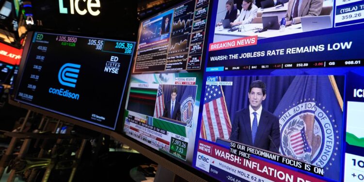 Screens display a news conference held by Federal Reserve chairman Kevin Warsh on the floor of the New York Stock Exchange in New York, Wednesday, Sept. 16, 2026. (AP Photo/Seth Wenig)