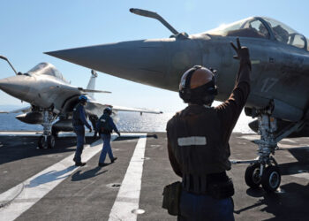 French Navy officers prepare a Marine Rafale fighter aircraft before takeoff on the flight deck of the Charles de Gaulle aircraft carrier as it returns from its 'Lafayette 26' mission near Bonifacio off the coast of the French island of Corsica, southern France on July 10, 2026. (Photo by Pascal POCHARD-CASABIANCA / AFP)