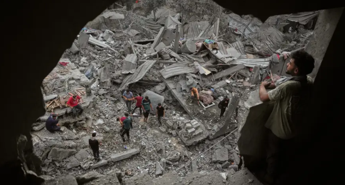 فلسطينيون يتفقدون مبنى بعدما قصفه جيش الاحتلال